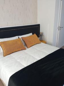 巴塔拉Alojamento Local Vitoria的床上有两个橙色枕头