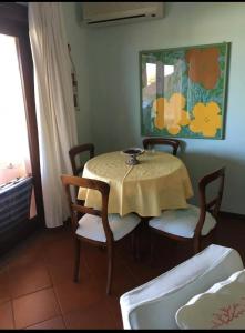 切尔沃港Appartamento Porto Cervo Dolce Sposa的一间带桌椅和绘画的用餐室