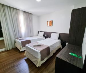 马塞约海岛大亨亚酒店 的配有绿色温度计的酒店客房内的两张床