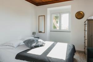 劳林哈Bird House的白色的卧室设有床和窗户