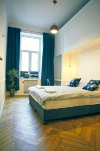 华沙4th Floor Bed and Breakfast的一间卧室配有一张带蓝色窗帘的大床