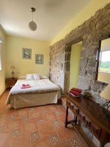 ChancelasCasa Hortiñas的一间卧室设有一张床和石墙