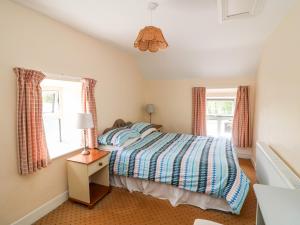 海上费萨德Grange Farmhouse的一间卧室设有一张床和两个窗户。