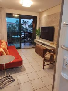 嘎林海斯港Flat Experience Marulhos Resort的客厅配有红色沙发和平面电视
