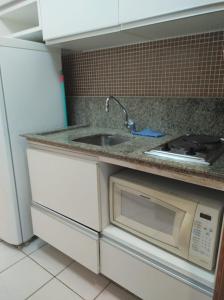 嘎林海斯港Flat Experience Marulhos Resort的厨房配有水槽和微波炉