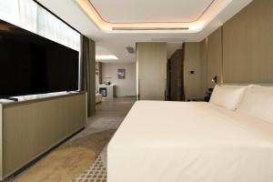 武汉武汉广场汉口金融中心亚朵酒店的卧室配有一张白色大床和一台平面电视。