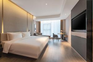 西安西安凤城五路经开中心亚朵酒店的酒店客房设有一张白色大床和一台电视。
