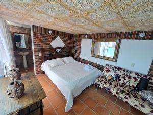 洛斯桑托斯Parque Mirador del Chicamocha的一间卧室设有一张床和砖墙