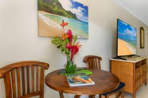 卡帕阿Islander Ocean Resort Condo # 166的一张餐桌,上面有花瓶