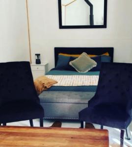 莱文The kauri Tree Pod - Off Grid Experience的一间卧室配有一张床和两把椅子