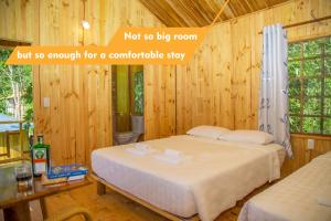 富国Sim Bungalow的木制客房内的一间卧室,配有一张床