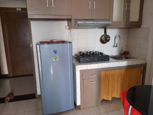 茂物Apartemen Bogor Valley Family Staycation的厨房配有冰箱和炉灶。