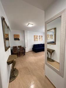 多列毛利诺斯TORREMOLINOS CENTRO - Beautiful , newly renovated 2 bedroom apartment的客厅配有蓝色的沙发和镜子