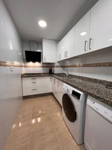 多列毛利诺斯TORREMOLINOS CENTRO - Beautiful , newly renovated 2 bedroom apartment的厨房配有白色橱柜和洗碗机。