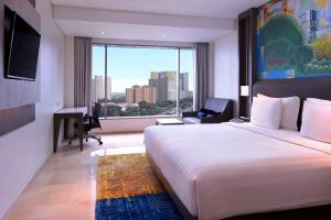 雅加达雅加达马腰兰美爵酒店 的一间设有大床和窗户的酒店客房