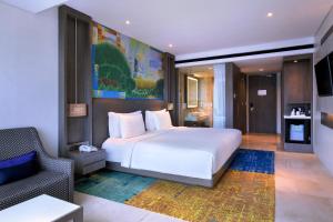 雅加达雅加达马腰兰美爵酒店 的卧室配有白色的床和椅子