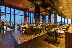 塞米亚克塞米亚克双六豪华酒店的餐厅设有桌子和绿色椅子以及窗户。