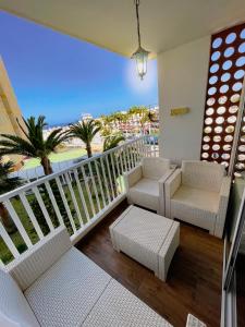阿罗纳Harmony Apartments的一个带椅子的阳台,享有海滩美景