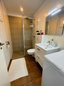 阿罗纳Harmony Apartments的带淋浴、卫生间和盥洗盆的浴室