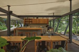 外南梦Lintang Luku Tent Resort的开放式厨房和用餐区配有木桌