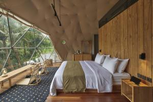 外南梦Lintang Luku Tent Resort的一间卧室设有一张床和一个大窗户