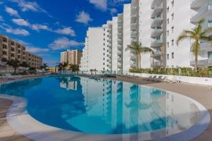 阿罗纳Luxury apartment in Ocean Garden Playa Paraiso的一座大型游泳池,位于部分建筑前