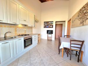 伊格莱西亚斯Saludi&Trigu - Rural Apartments的厨房配有白色橱柜和桌椅