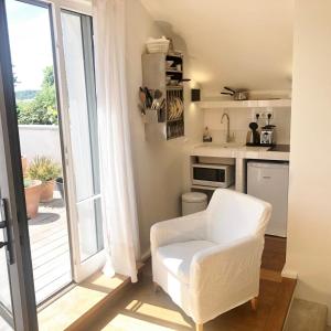 凡尔赛Denis & Virginie - château à pied - parking gratuit的一间带白色椅子的客厅和一间厨房