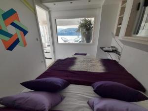 波维尔亚Apartment OM的一间卧室配有一张带紫色枕头的床和窗户。