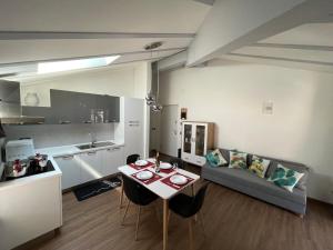 特伦托Appartamento Le 3 Cime的厨房以及带桌子和沙发的客厅。