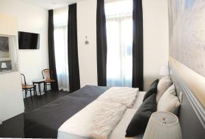 栋堡DAC50 Luxurious apartment Domburg的一间卧室配有一张带白色床单和黑色窗帘的床。