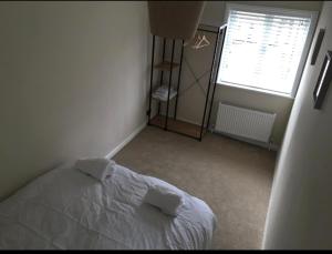 诺里奇A quaint Wymondham cottage的卧室配有白色的床和窗户。