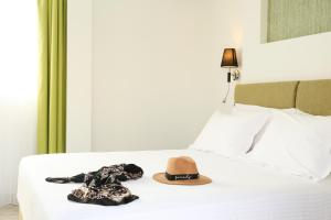 雅典Athens Starlight Hotel的床上的帽子和连衣裙