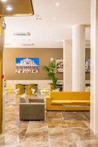 莱切Mercure Hotel President Lecce的大堂设有黄色的沙发和桌子