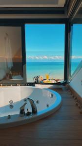 特拉布宗Peerless Villas Hotel的带浴缸的浴室,享有海景