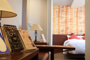 东京BOOK HOTEL 神保町的酒店客房,配有床和桌子,备有书籍