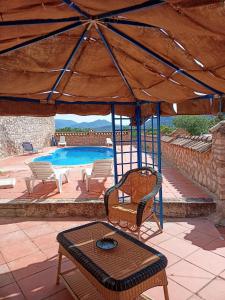 CarchelejoEL CONVENTO Vivienda Rural Jaén Andalucía España的一个带桌椅的庭院和一个游泳池