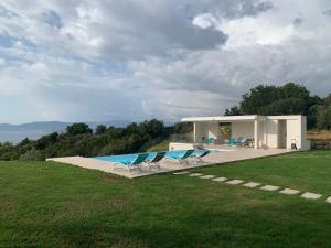 皮耶特罗塞拉CORSE HOLISTIKA - Rez-de-jardin avec vue mer exceptionnelle et piscine magnifique的一座带游泳池和两把椅子的房子