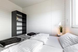 梅尔诺New Wave Resort Mielno的白色墙壁客房的两张床