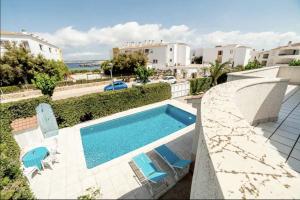 桑坦德利亚湾Villa with pool in Cala Blanca with sea views的一个带躺椅的游泳池和一个游泳池