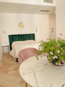 利帕里B&B Faraglione的一间卧室配有一张床、一张桌子和鲜花
