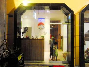 日惹巴杨卡拉小屋酒店的站在商店橱窗里的男人和孩子