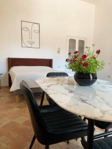 利帕里B&B Faraglione的一间设有桌子、一张床和鲜花桌的房间
