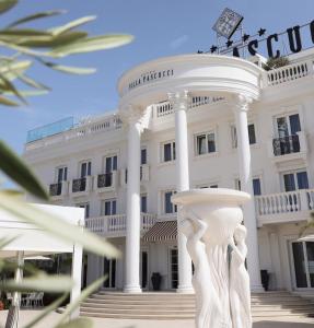 都拉斯Hotel Villa Pascucci的前面有雕像的白色建筑
