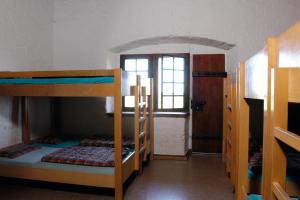 MariasteinMariastein-Rotberg Youth Hostel的客房设有三张双层床和一扇窗户。