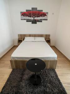 RoşuMilitari Studio的一张床上,有一张黑凳子在房间里