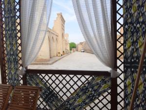 希瓦"YOQUT HOUSE" guest house in the centre of ancient city的阳台配有窗帘,享有街道景致。