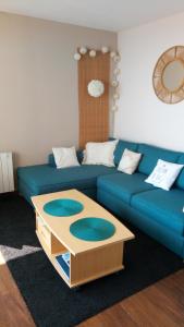 阿卡雄Comme dans un phare的客厅配有蓝色的沙发和茶几