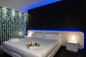 波尔图·埃尔科莱埃尔科莱港口酒店的一间卧室配有一张床,上面放着一个食物托盘