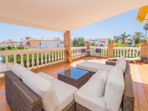 马拉加Cubo's Villa Yedra Guadalmar的露台配有白色家具,甲板上设有栏杆